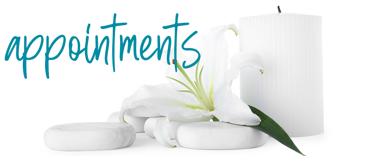 white candle with white lily and white rocks